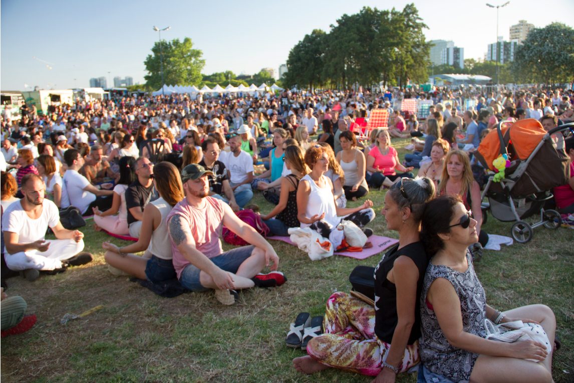 Miles de personas meditando juntas al aire libre